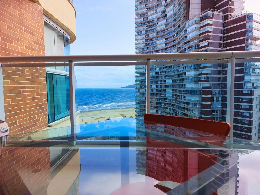 a balcony with a bench and a view of the ocean at Book Santos Mar à Vista no Unique Residence 1810 in Santos
