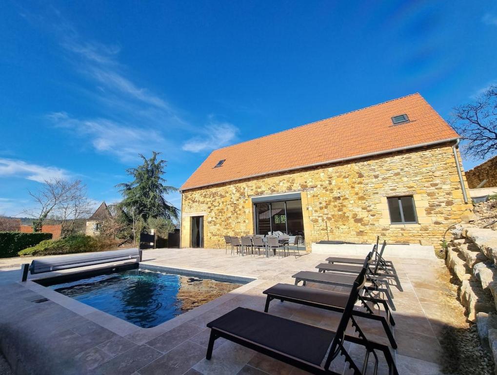 une maison avec une piscine et des chaises dans l'établissement T6 avec piscine en Dordogne, à Nabirat