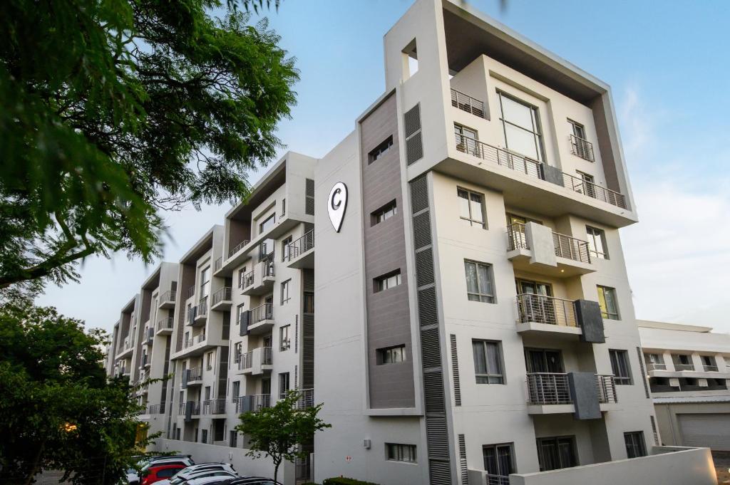 a tall white building with a clock on it at The Capital on Bath in Johannesburg