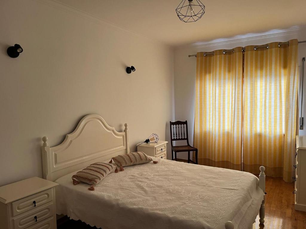 a bedroom with a white bed and a chair at Ancoravilla in Vila Praia de Âncora
