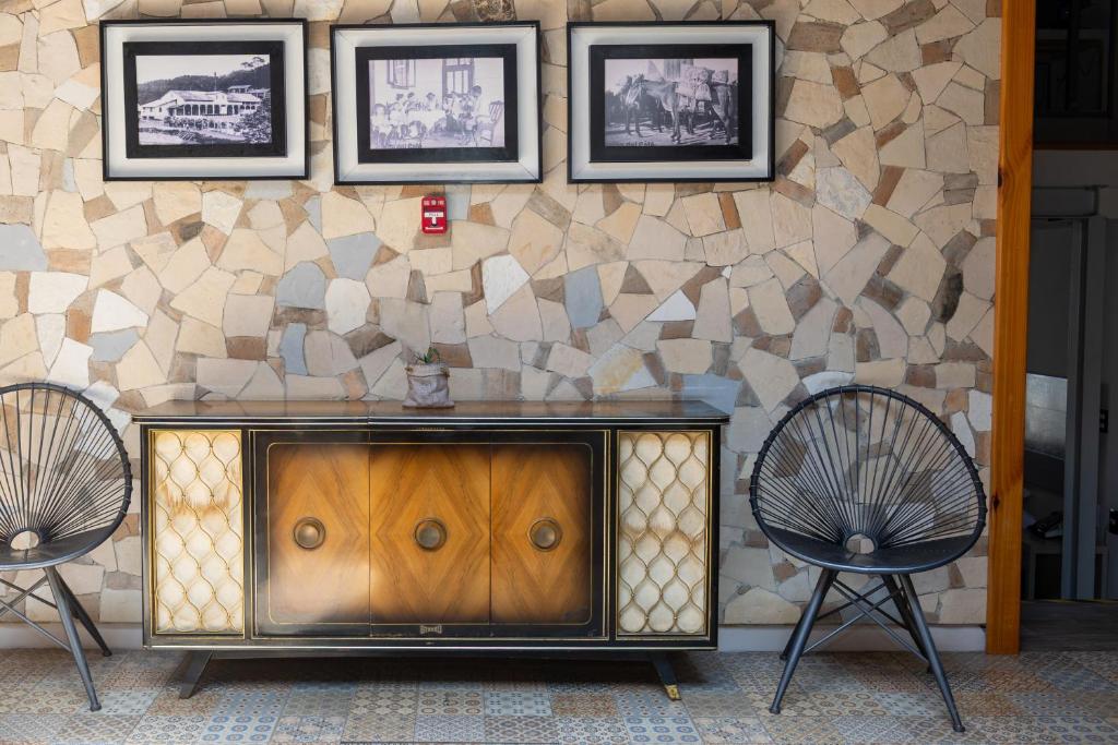 two chairs sitting next to a wooden cabinet against a wall at Corazón Del Café Hotel Boutique in Comitán de Domínguez
