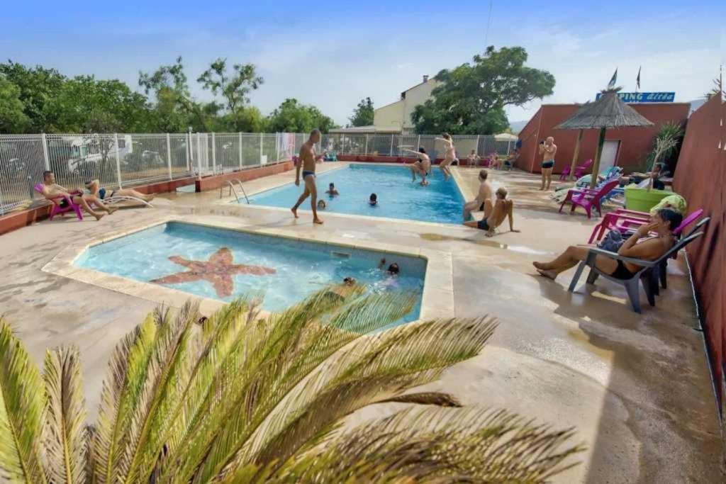 un groupe de personnes assises autour d'une piscine dans l'établissement Camping 3 étoiles - Piscine - eehfhg, à Vic-la-Gardiole