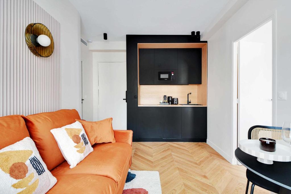 un salon avec un canapé et une cuisine dans l'établissement Cozy Entire Apartment Near the Eiffel Tower, à Paris