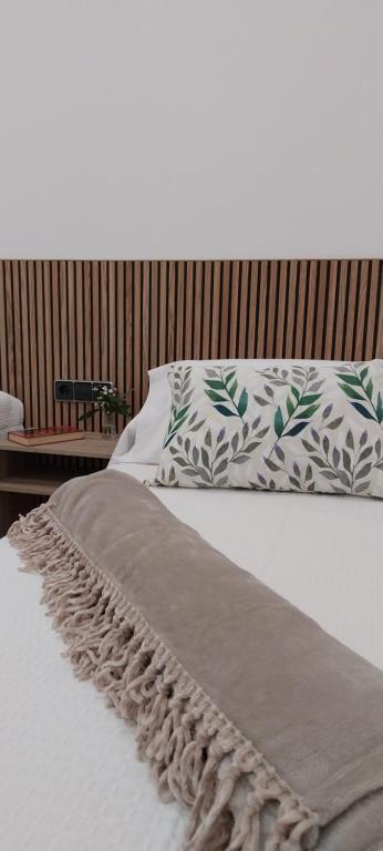 a bed with a blanket and pillows on it at PILGRIMSROOM la Parada Del Camino in Negreira