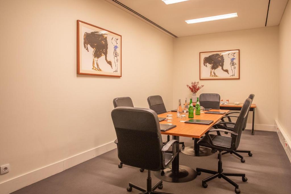 A compact conference room is arranged around a rectangular table for meetings.