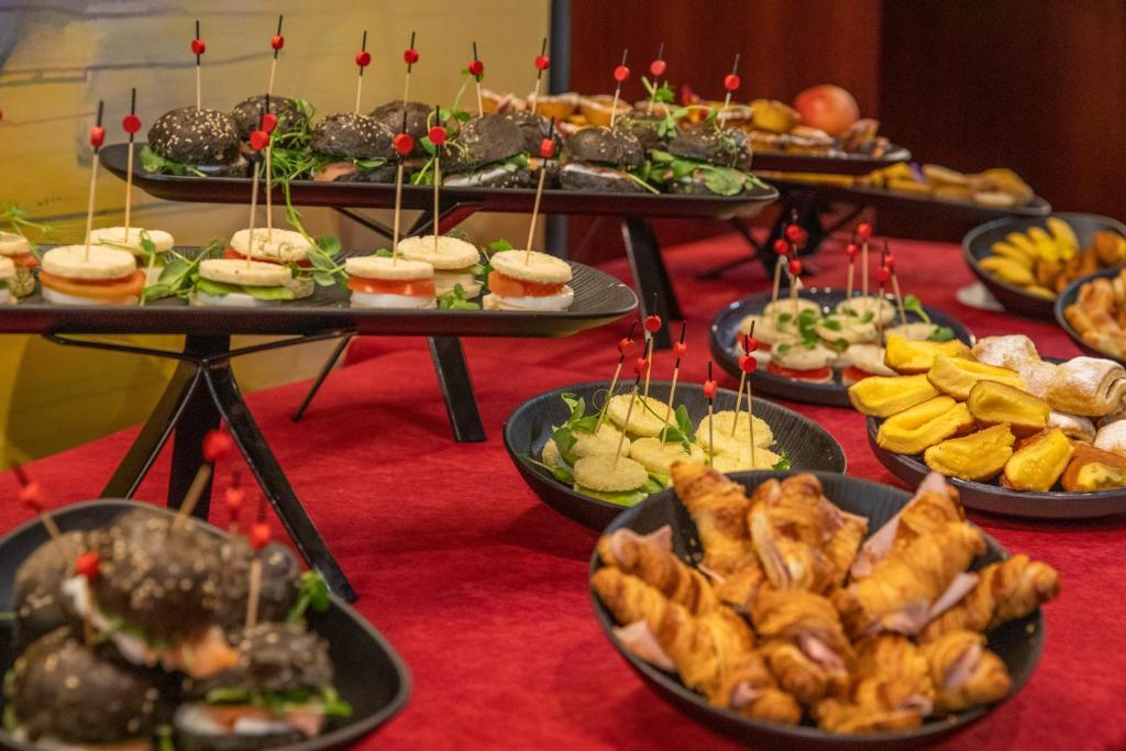 A catered spread of sandwiches, pastries, fruit and bite-sized dishes.