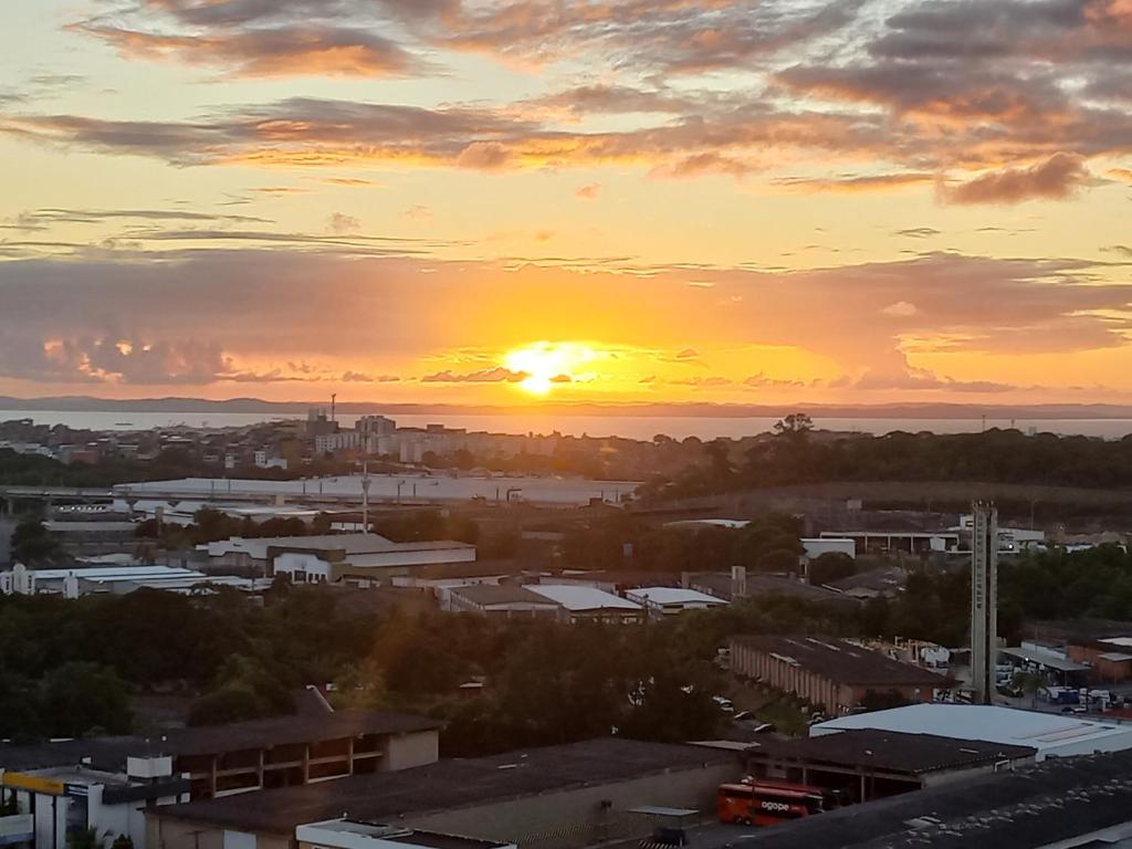 a view of a city with the sunset in the background at Condomínio Reserva da Colina in Salvador