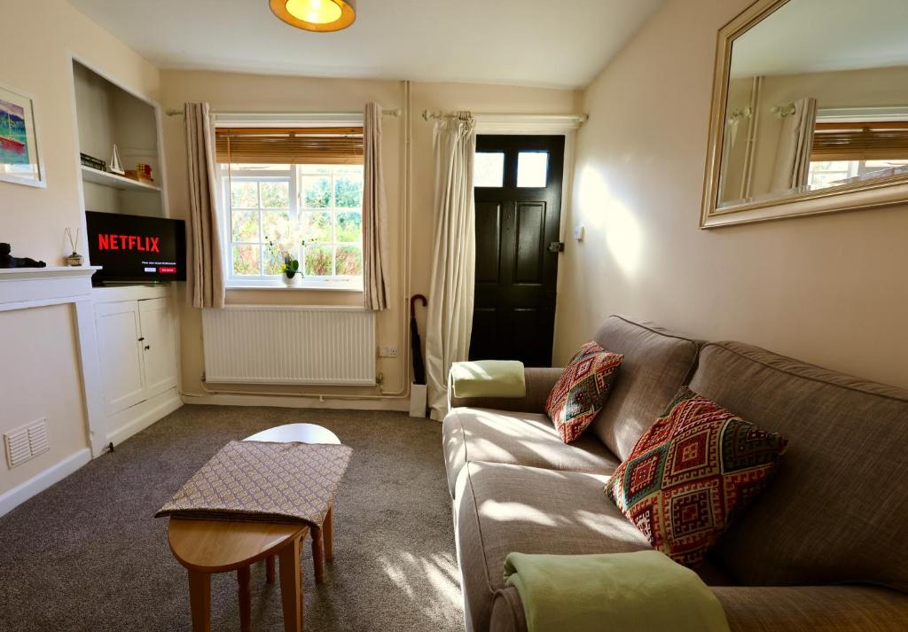 ein Wohnzimmer mit Sofa und Tisch in der Unterkunft Deben Cottage, Central Woodbridge in Woodbridge