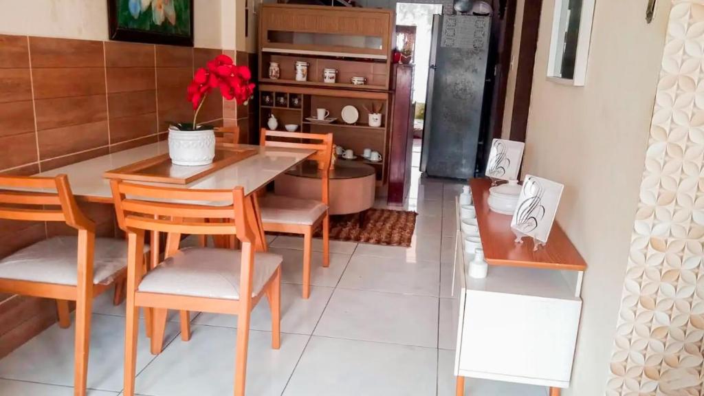 a dining room with a wooden table and chairs at Seu Refúgio a 100m da Praia do Sobral - Maceió in Maceió