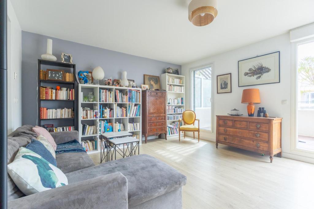 - un salon avec un canapé et des étagères dans l'établissement Le Duplex des Catalans, à Marseille