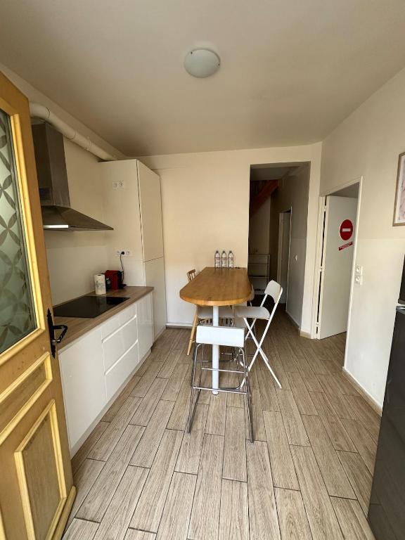 a kitchen with a table and chairs in a room at Belle maison à 11 mm des Champs Élysées in Nanterre
