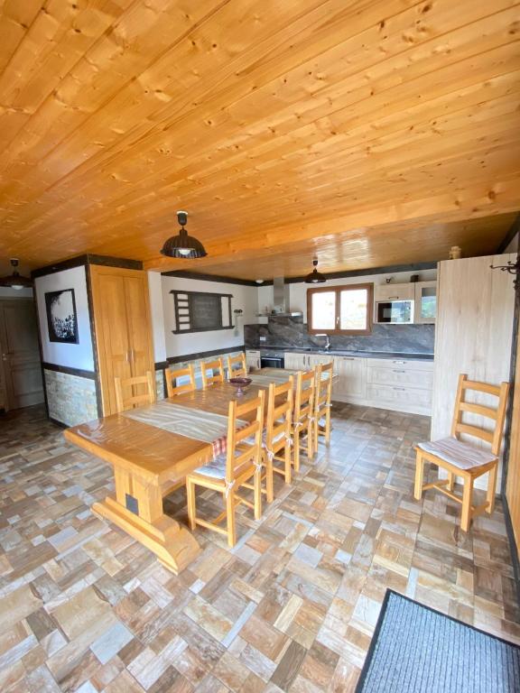 une salle à manger avec une table et des chaises en bois dans l'établissement LE GRENIER DES MIOS, à La Bresse