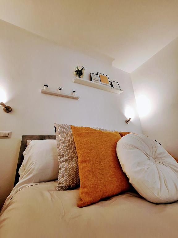 a bedroom with a bed with two pillows on it at Elunà Assisi Home in Assisi