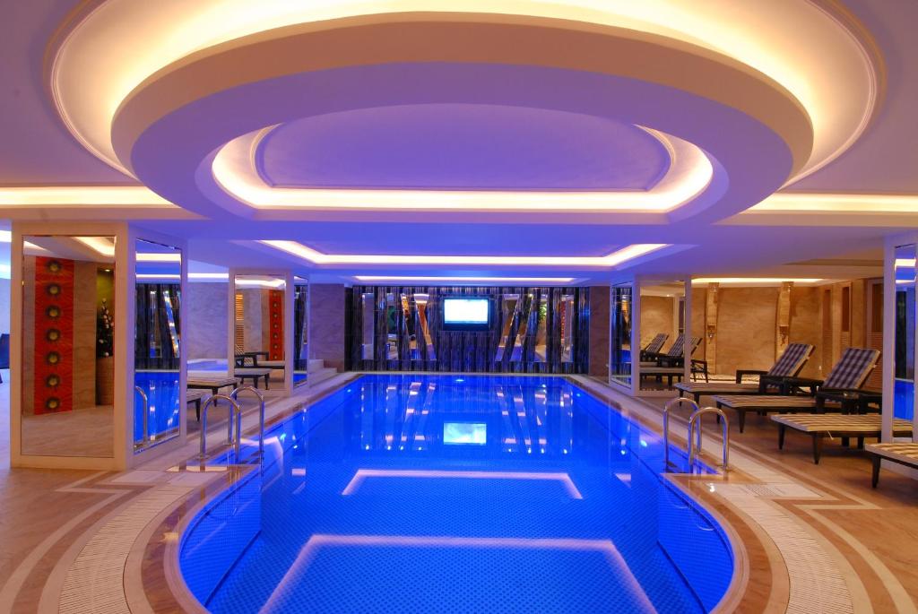 a swimming pool in a hotel with a purple ceiling at Mosaic Hotel Old City -Special Category in Istanbul
