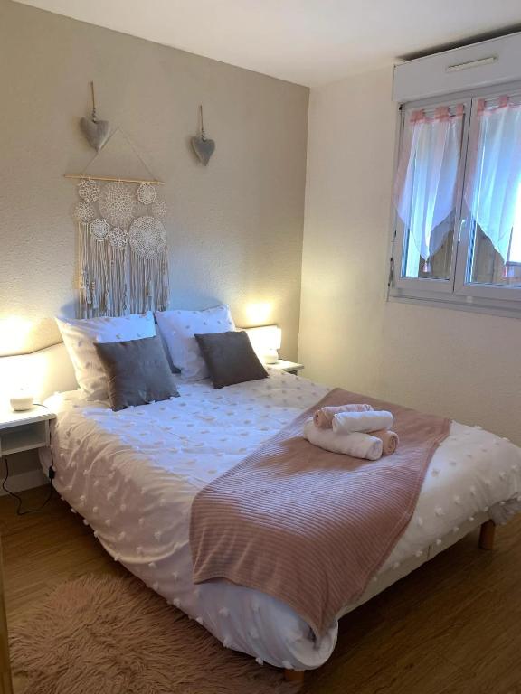 une chambre avec un grand lit blanc avec deux serviettes dessus dans l'établissement Appartement charmant à Bagnères-de-Bigorre - 56 m² avec balcon, à Bagnères-de-Bigorre