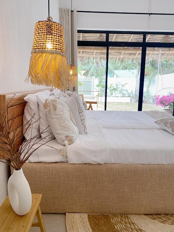 una camera da letto con un grande letto con una grande finestra di CASA BUKO Tropical Homes El Nido a El Nido