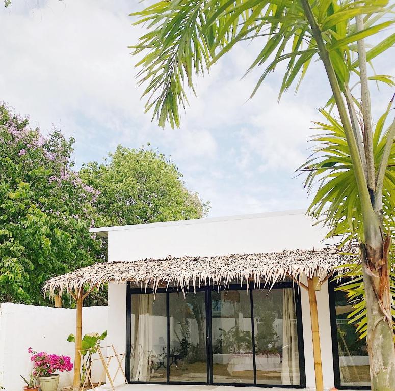 un edificio con tetto di paglia e palma di CASA BUKO Tropical Homes El Nido a El Nido