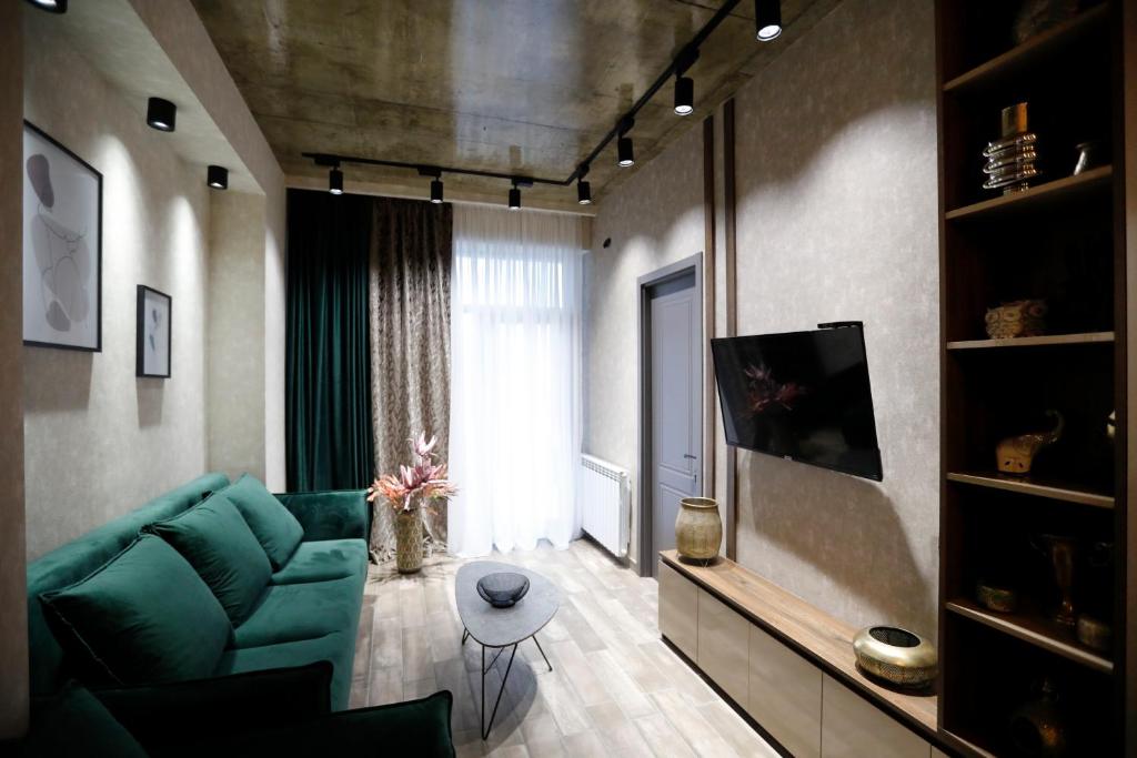 un salon avec un canapé vert et une fenêtre dans l'établissement Cozy apartment for travelling, à Tbilissi