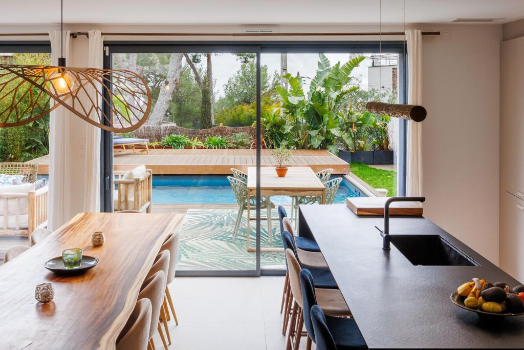 una sala da pranzo con tavolo, sedie e piscina di Villa Cosy Neuve 8 min à pieds des plages a Cassis