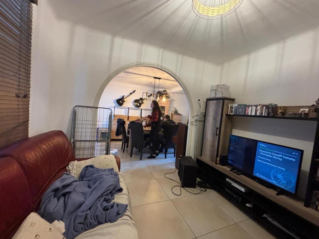 un salon avec un canapé et une télévision dans l'établissement Les Naïades, à Antibes