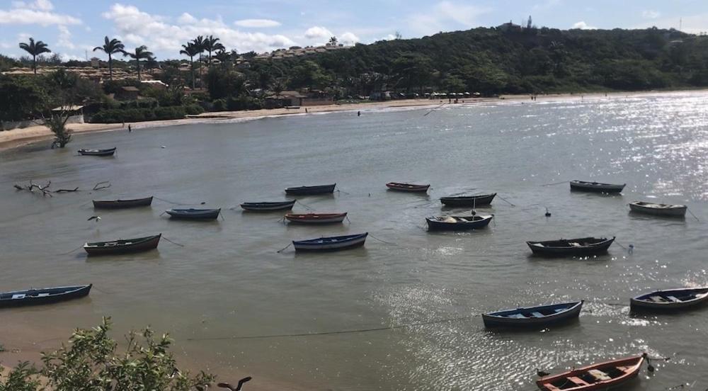 un groupe de bateaux dans l'eau sur une plage dans l'établissement Casa Hamburgo 5 pessoas, à Búzios