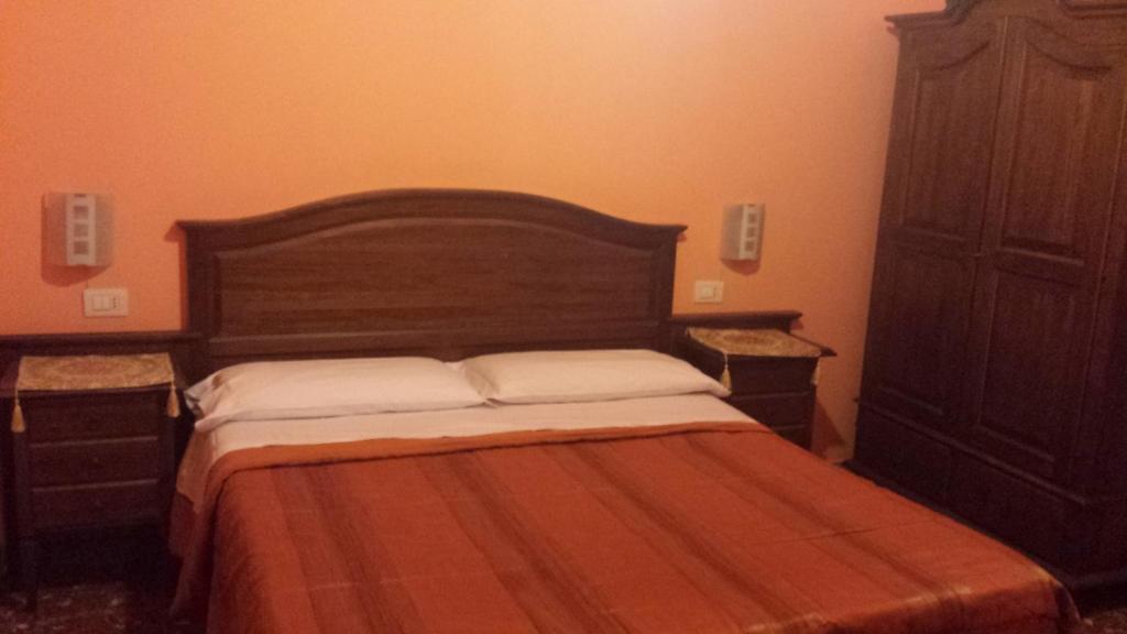 ローマにあるピタゴーラ B＆Bのベッドルーム1室(木製ヘッドボード付きのベッド1台付)