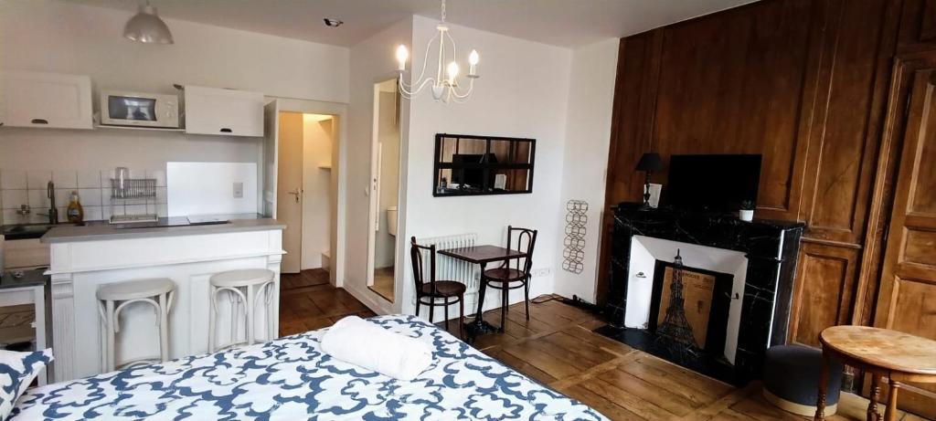 - une chambre avec un lit, une cheminée et une table dans l'établissement La Suite Sinatle Rennes Hyper Centre - 2 personnes, à Rennes