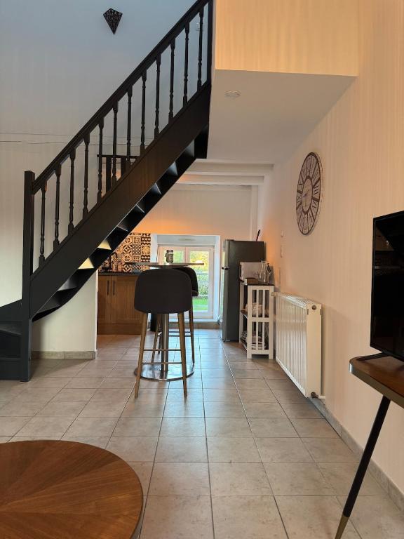 - un salon avec un escalier, une table et un tabouret dans l'établissement Le trente 30, à Jeuxey