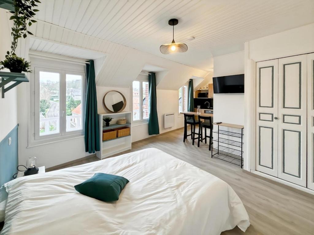 une chambre avec un grand lit blanc et une cuisine dans l'établissement Studio Horizon Bleu, à Criel-sur-Mer