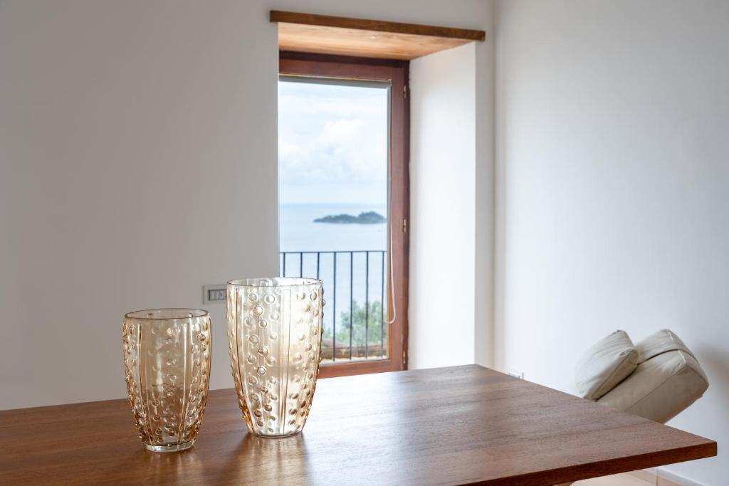 a dining room table with two glass vases on it at La Torre tra gli Ulivi di Positano in Piano di Sorrento