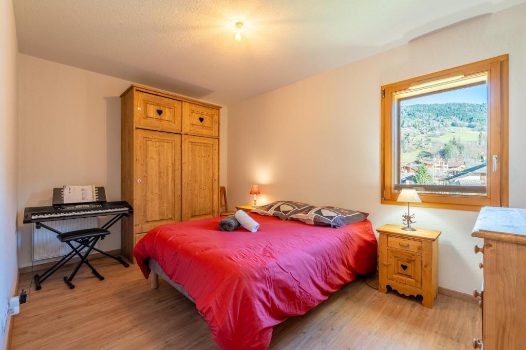 ein Schlafzimmer mit Bett, Schreibtisch und Fenster in der Unterkunft Appt Cosy centre ville à 5 min des stations de ski in Saint-Jean-de-Sixt
