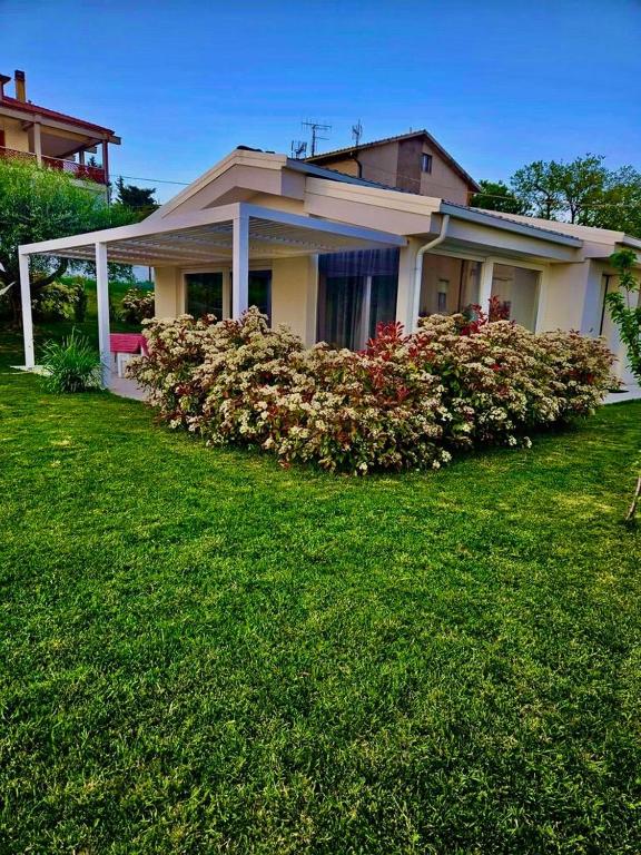 a house with a flower bush in front of it at White House in Civitanova Marche