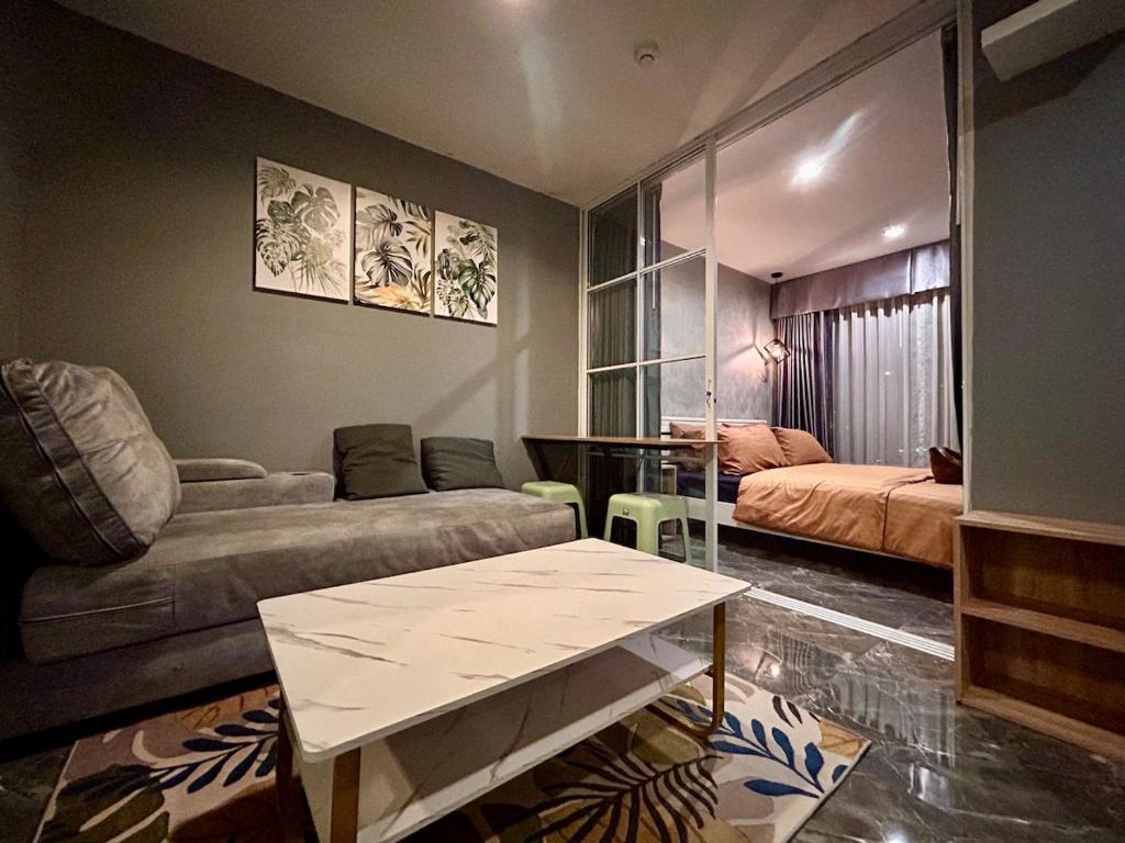 a living room with a couch and a table at Modern2 1BR at Bangson in Bangkok