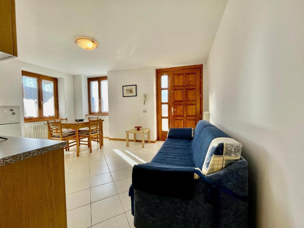 a living room with a blue couch and a table at Trilo La Rindela in Folgaria