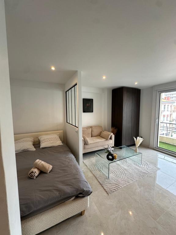 une chambre avec un lit et une table en verre dans l'établissement Suite le Venitia - Appartement standing, à Cannes