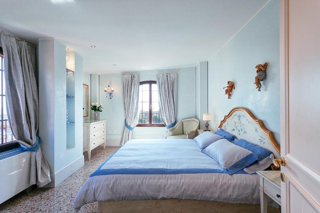 a bedroom with a bed with blue walls and windows at Deluxe Apartments Lagoon View in Venice