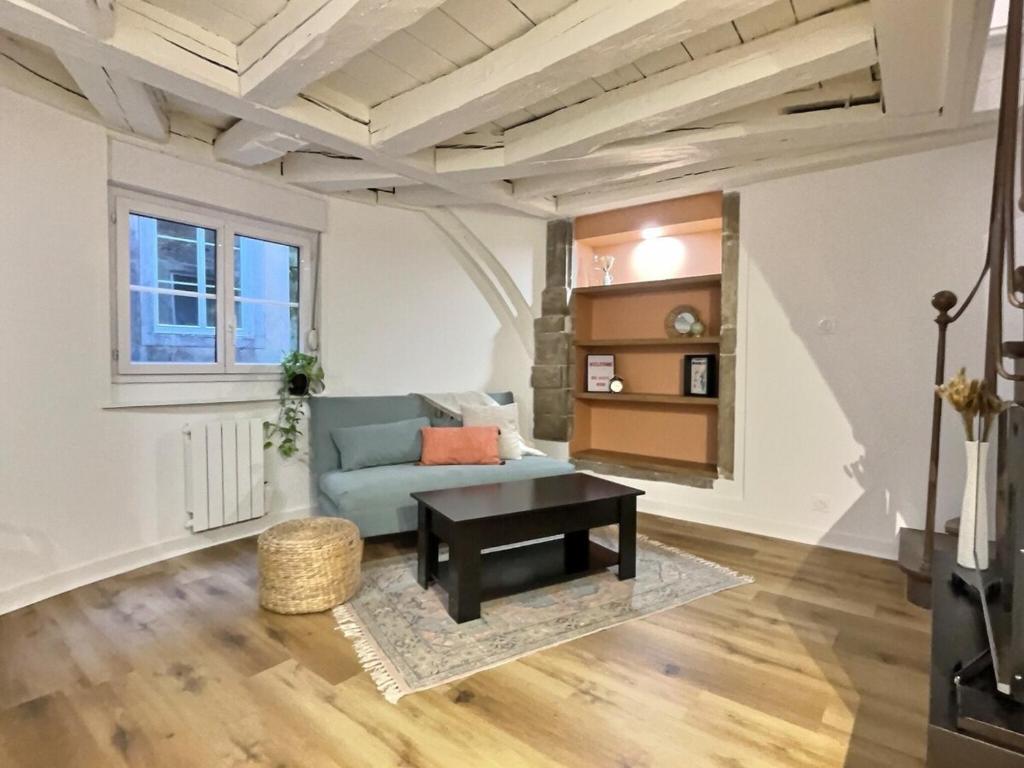 un salon avec un canapé bleu et une table dans l'établissement Romance Mâconnaise, à Mâcon