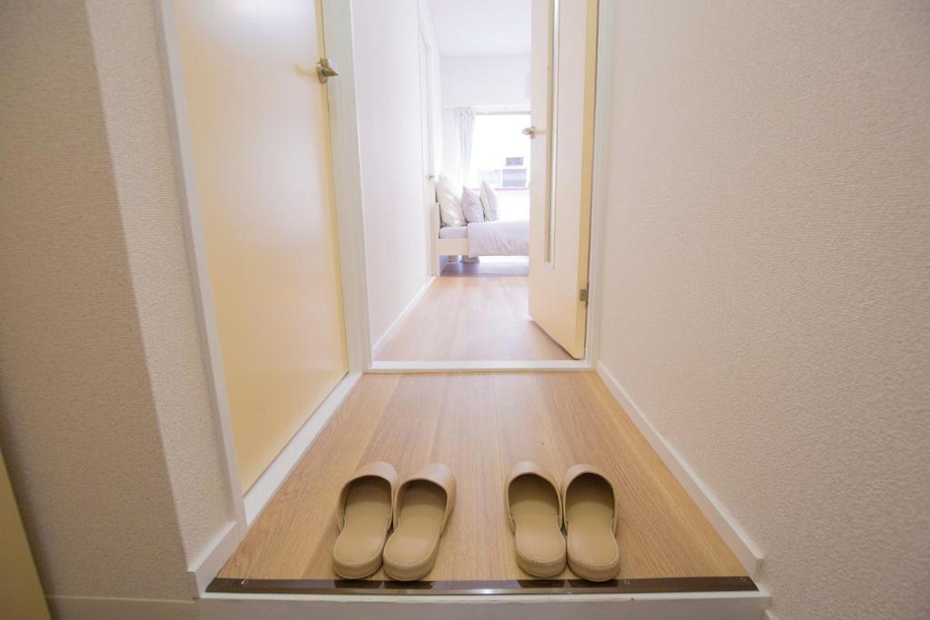 a pair of shoes in front of a mirror at 新宿駅 西武新宿駅近 歌舞伎町の快適ゲストハウス LoE3 in Tokyo
