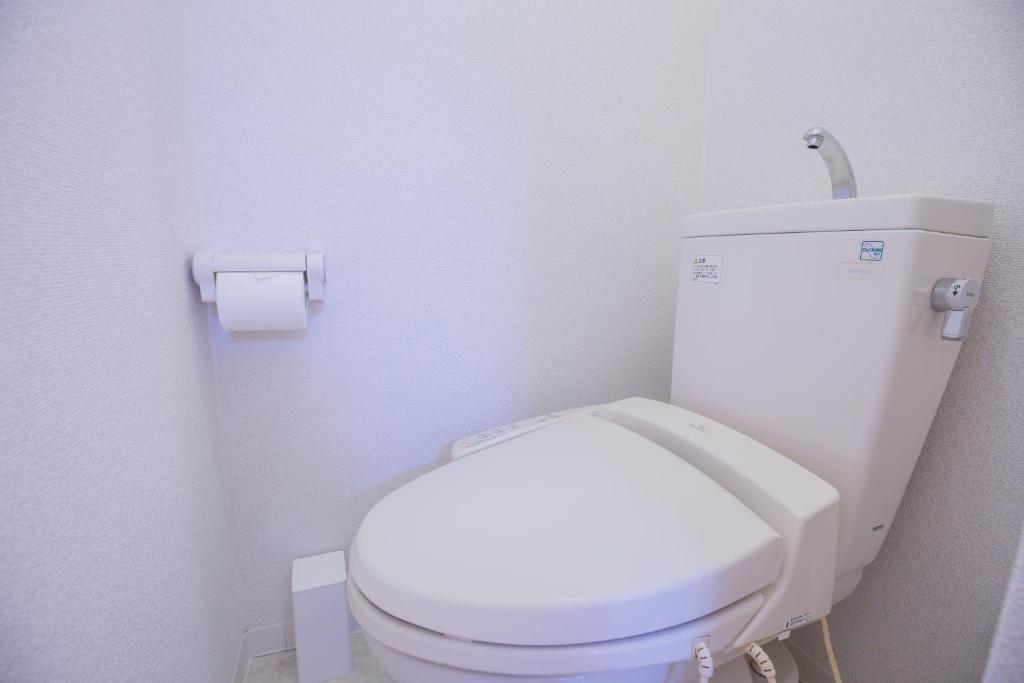 a bathroom with a white toilet with a roll of toilet paper at 新宿駅 西武新宿駅近 歌舞伎町の快適ゲストハウス LoE3 in Tokyo
