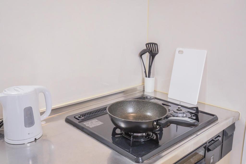 a frying pan on a stove in a kitchen at 新宿駅 西武新宿駅近 歌舞伎町の快適ゲストハウス LoE3 in Tokyo