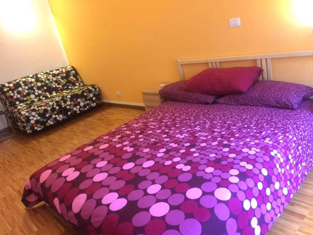 a bedroom with a purple bed and a chair at Lilith B&B in Turin