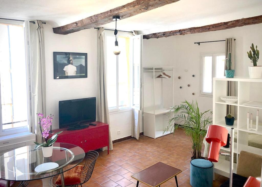 un salon avec une télévision et une table en verre dans l'établissement Appart de charme CLIM 37m2 T1 Hôtel de ville, à Aix-en-Provence
