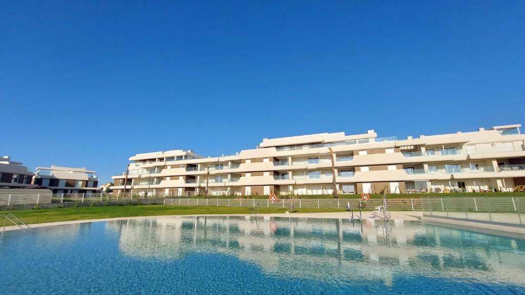 a large swimming pool in front of a building at Los Colibríes, Beach & Golf - By AC REAL in Isla Canela