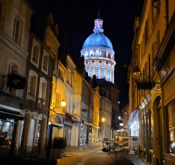 un bâtiment avec une tour éclairée la nuit dans l'établissement Appartement de charme RDC, à Boulogne-sur-Mer