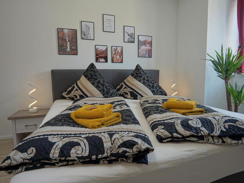 un letto con due coperte e asciugamani gialli sopra di Hogulu - urgemütliches Appartement 19 in der Altstadt a Brandenburg an der Havel