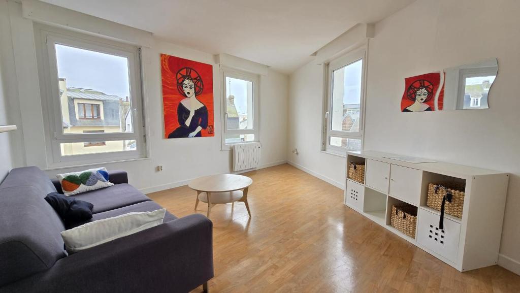 un salon avec un canapé et une table dans l'établissement Le Voyageur Coucher de soleil vue mer, à Berck-sur-Mer