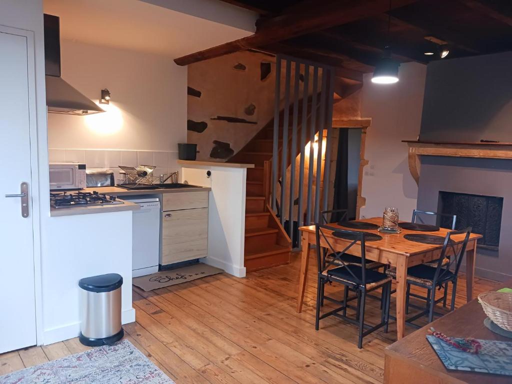 une cuisine avec une table en bois et une salle à manger dans l'établissement Gite La maison de Popey, à Saint-Romain-de-Popey