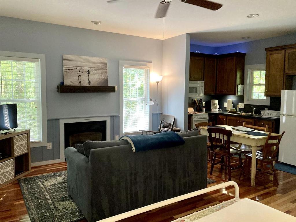 a living room with a couch and a kitchen at Secluded Woodland Cabin Rental with Hot Tub in Yadkin Valley Wine Region in Elkin