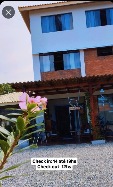 a house with a flower in front of it at QUINTAS DA BARRA BNB a 30m da praia in Balneario Barra do Sul
