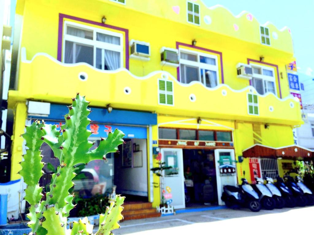 a yellow building with a cactus in front of it at Heart Seed B&B in Kenting